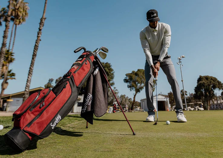 man golfing with red golf bag