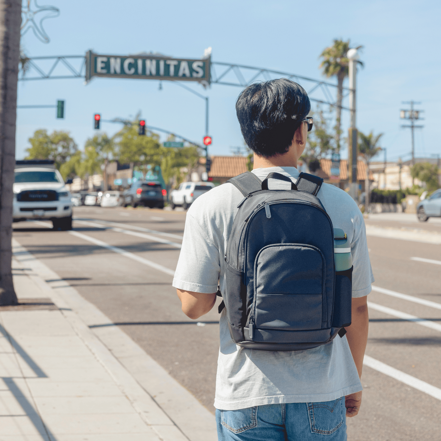 Person with Encinitas backpack standing on a street corner in Encinitas