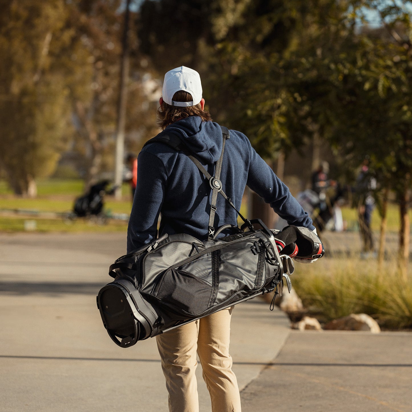 A man carrying The Ranger golf bag on his back on the course