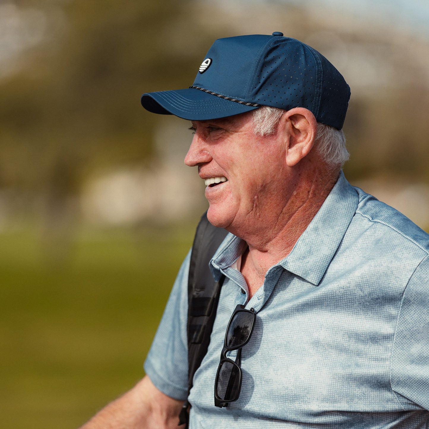 A man smiling while wearing navy Porter Lite golf hat