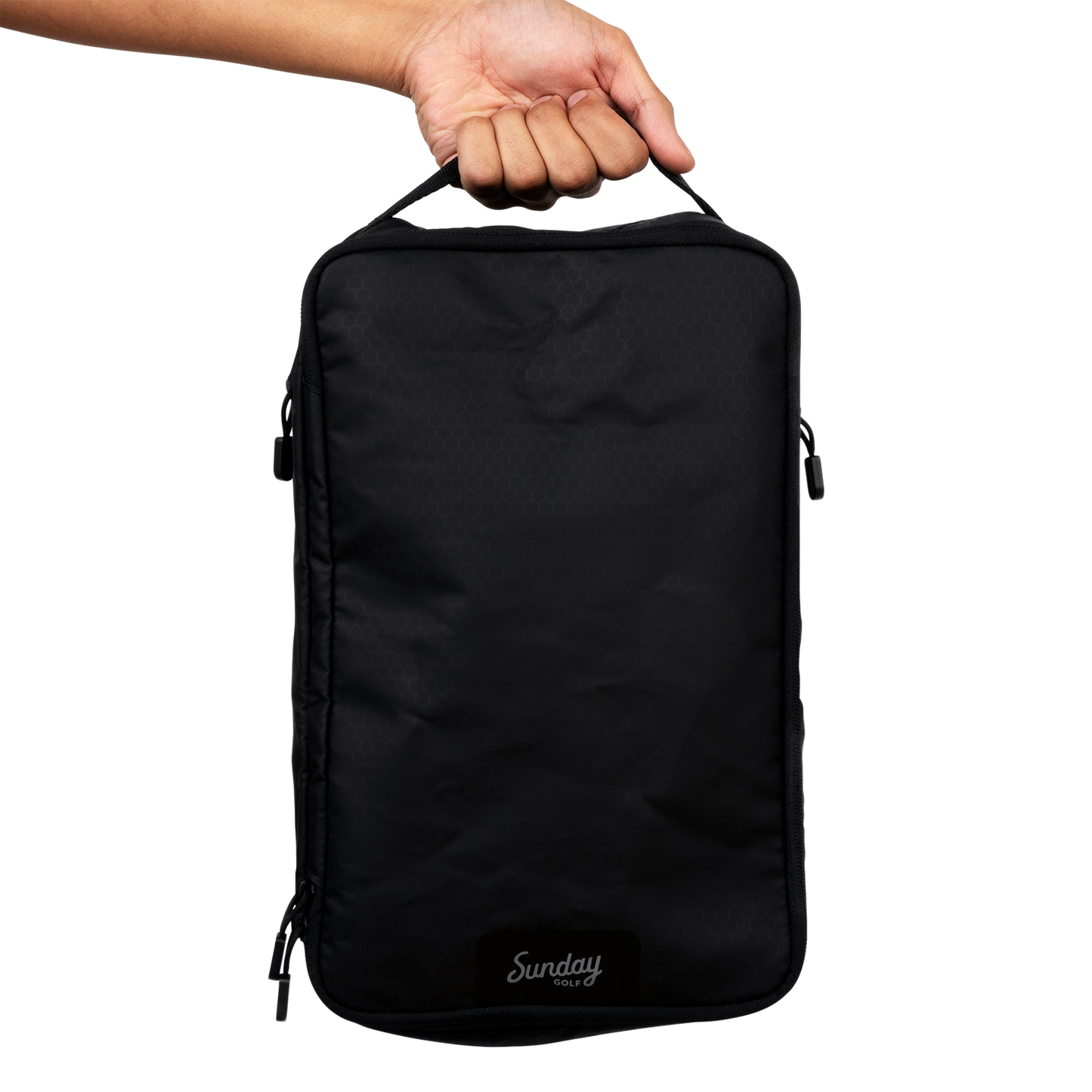 A hand holding a golf shoe travel bag showing how to carry it