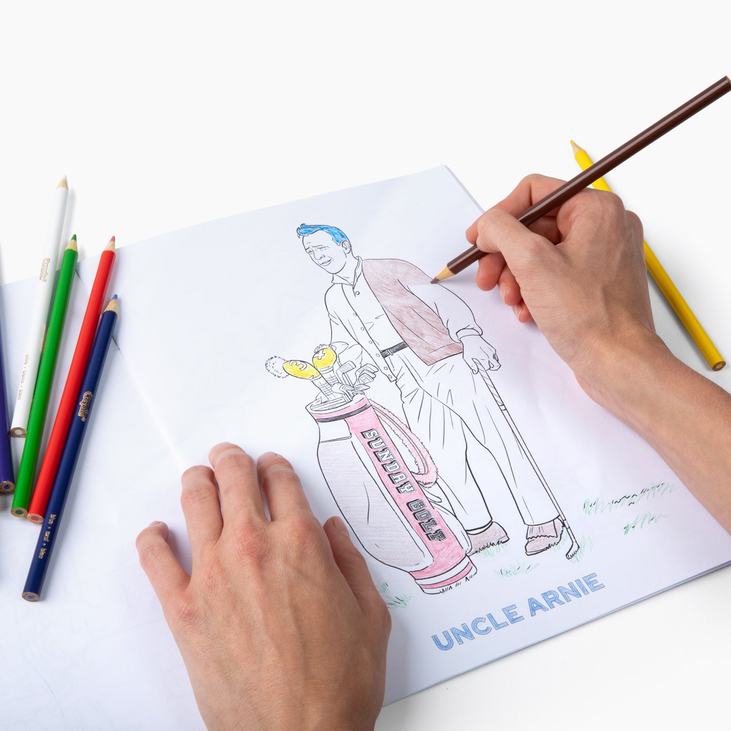 Coloring an illustration inside the book on golf bags using a color pencil