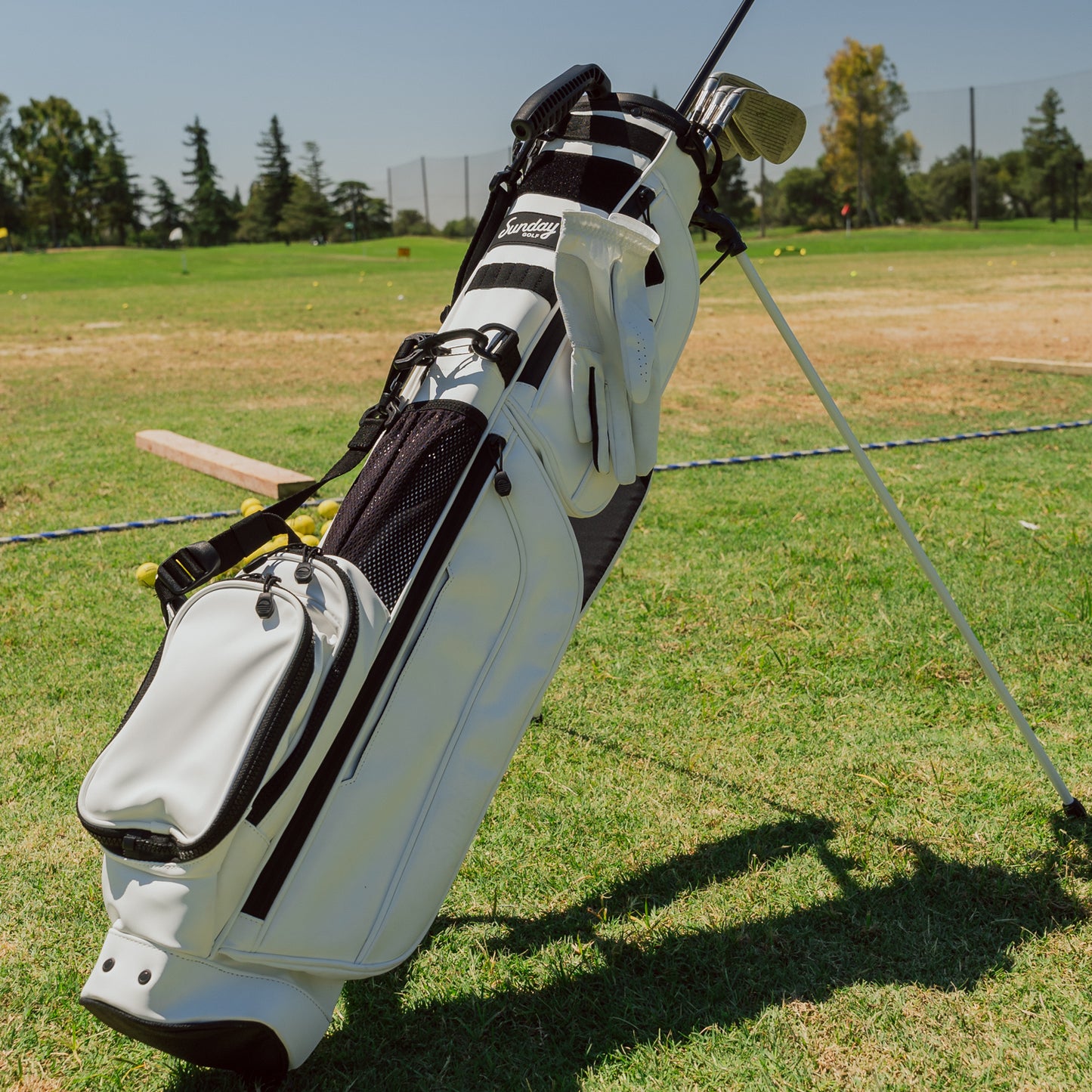 A full front shot on the course of standing Loma XL S-Class golf bag in white vegan leather