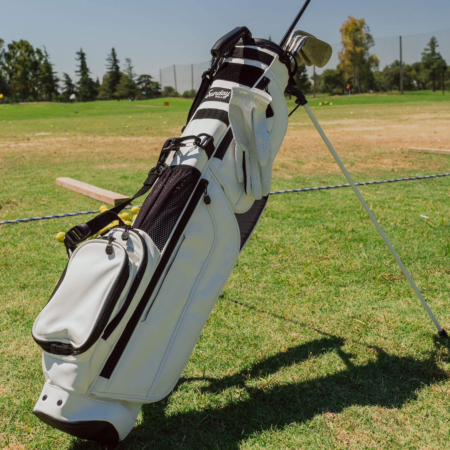A full front shot on the course of standing Loma XL S-Class golf bag in white vegan leather