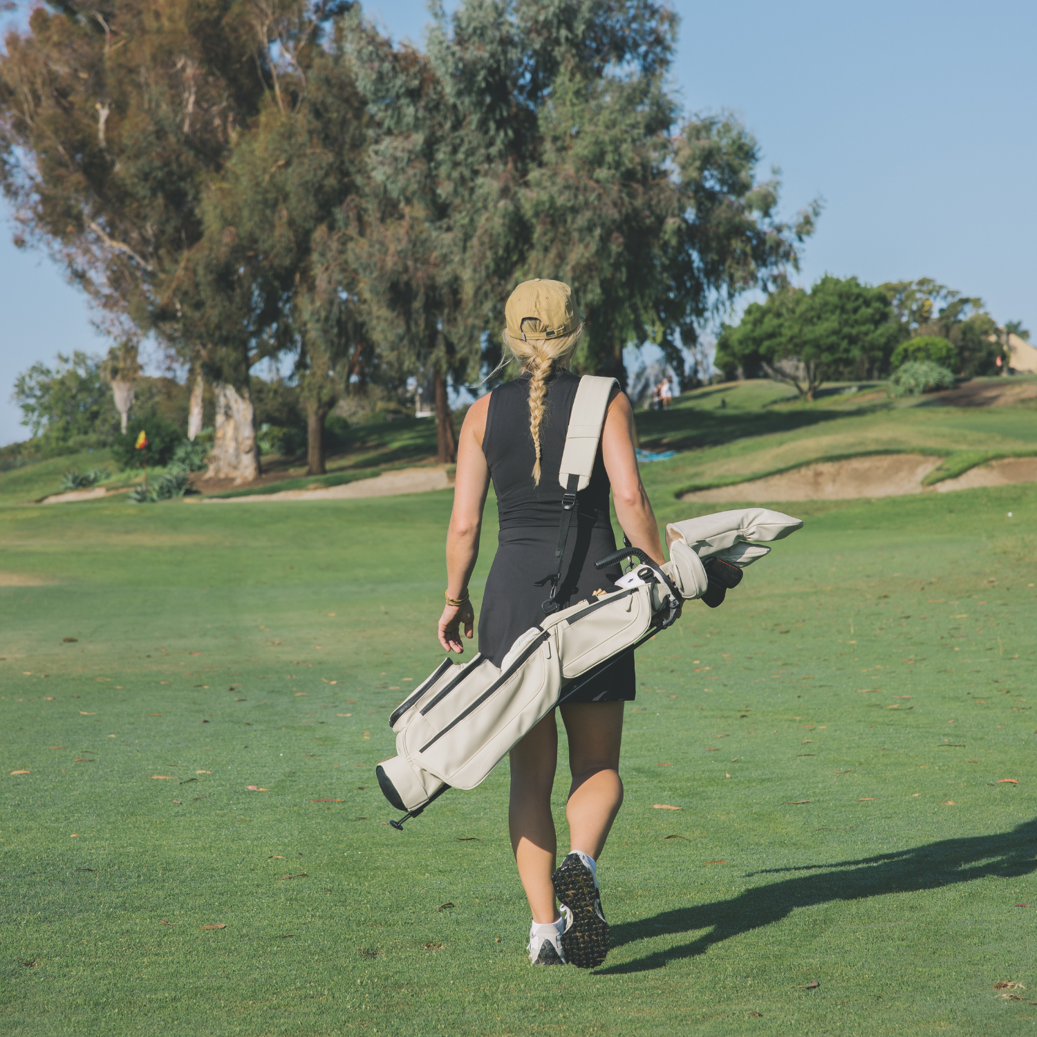 Woman walking on a golf course with Loma S-Class golf bag in Cream