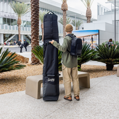 Man holding the Drifter Snow Travel Bag branding in the airport