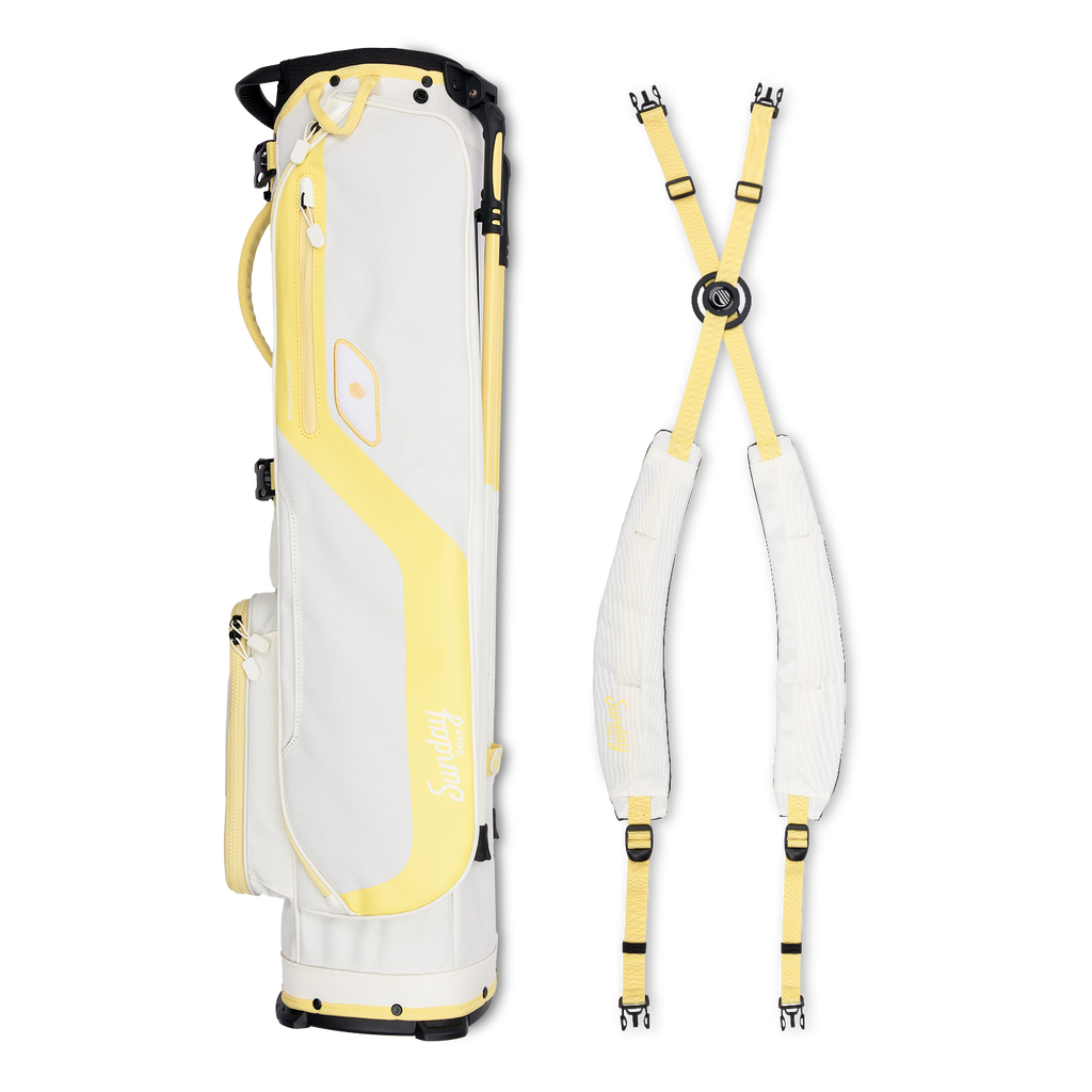 A full shot of El Camino golf bag in mindy lemon laying flat sideways beside its matching double strap