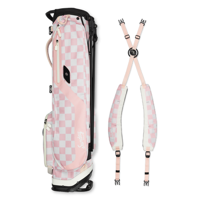 A full shot of El Camino golf bag in Pink/White Checker laying flat sideways beside its double strap 
