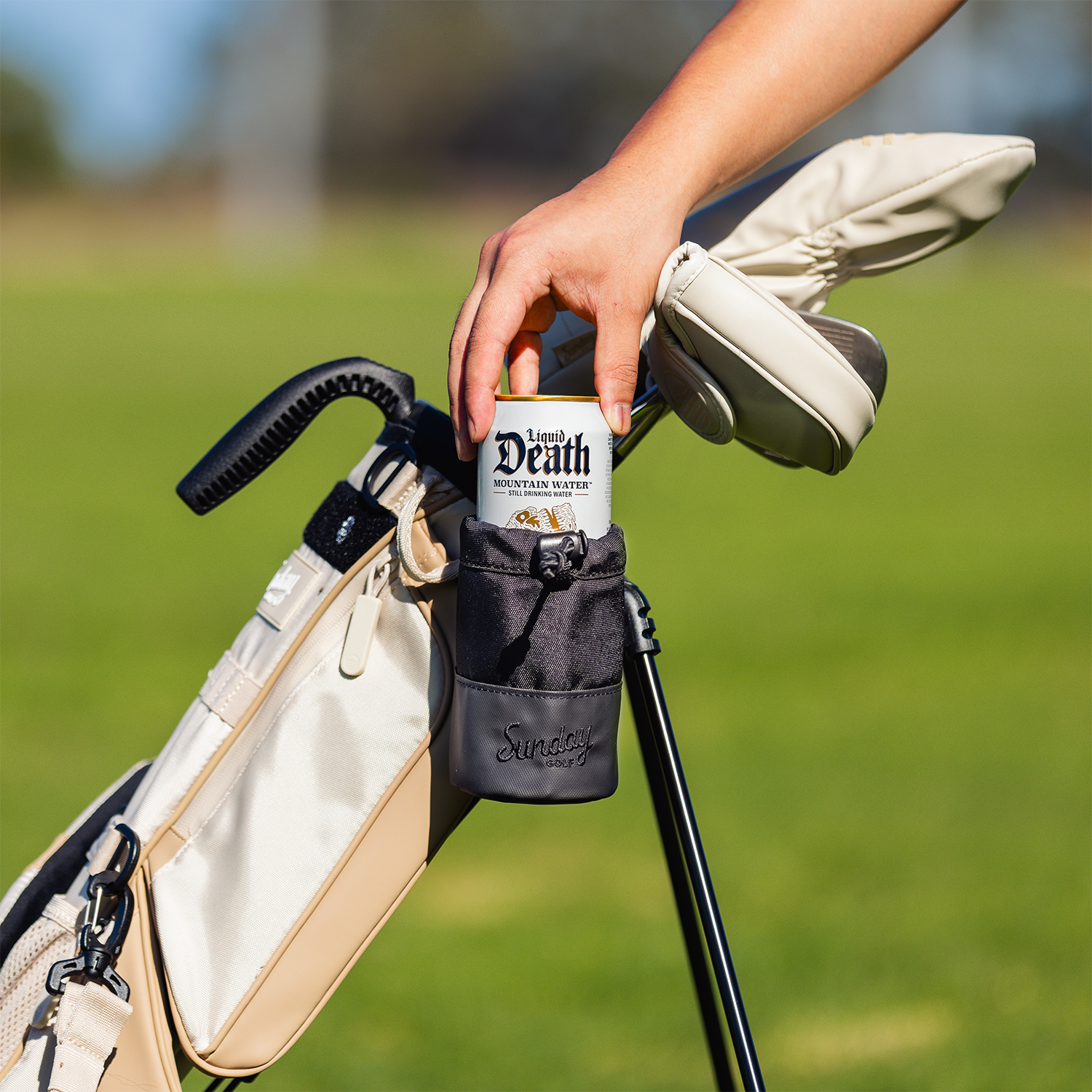 Loma Koozie containing an alcoholic drink in the golf field 