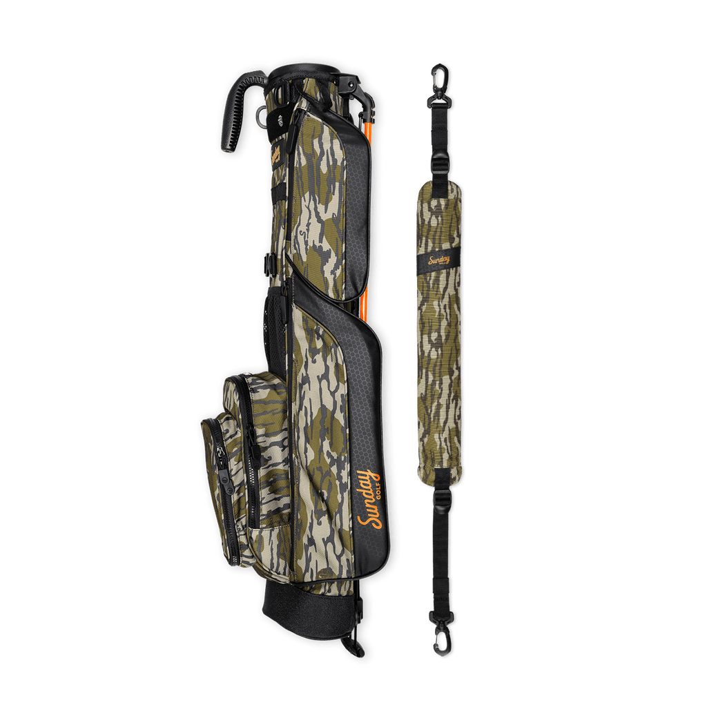 A full shot of Loma golf bag in mossy oak bottomland laying flat sideways beside its single strap