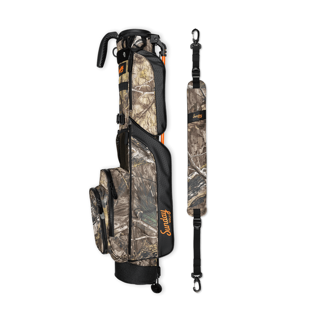 A full shot of Loma golf bag in mossy oak country dna laying flat sideways beside its single strap