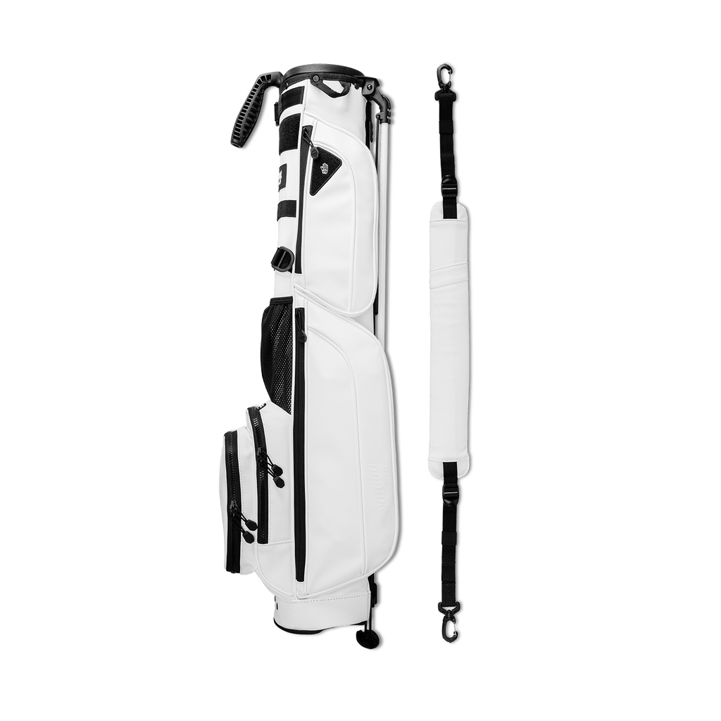 A full shot of Loma S-Class golf bag in white vegan leather laying flat sideways beside its single strap