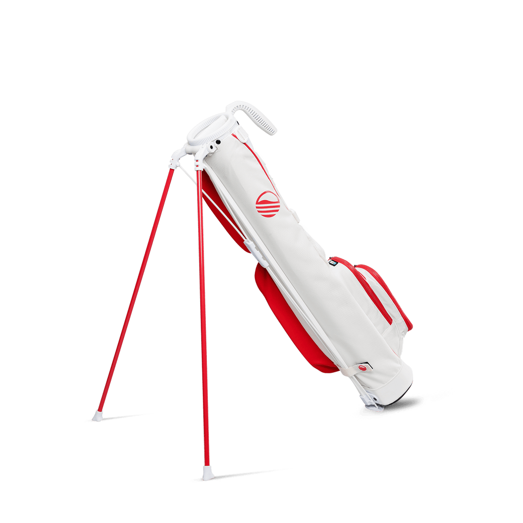 A full shot of standing Loma golf bag in red & off-white facing backward