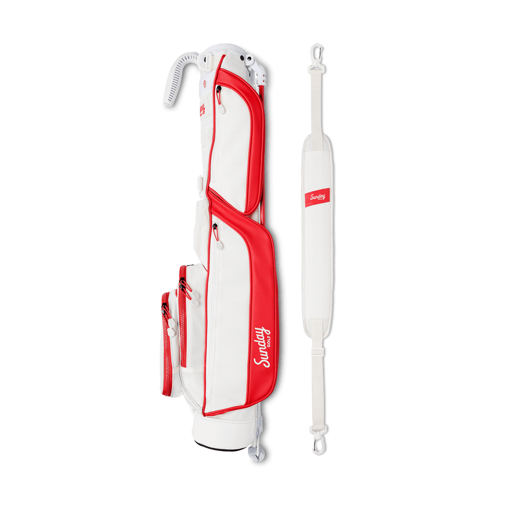 A full shot of Loma golf bag in red & off-white laying flat sideways beside its single strap