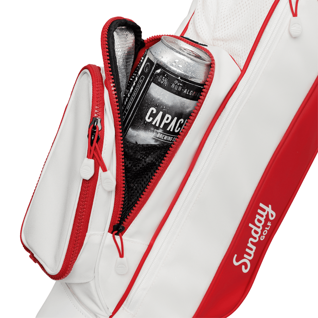 A close up shot of red & off-white Loma golf bag's insulated pocket with a canned drink inside