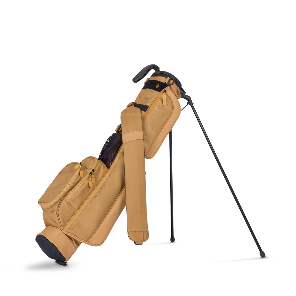 Tan golf bag with a black golf club on a white background