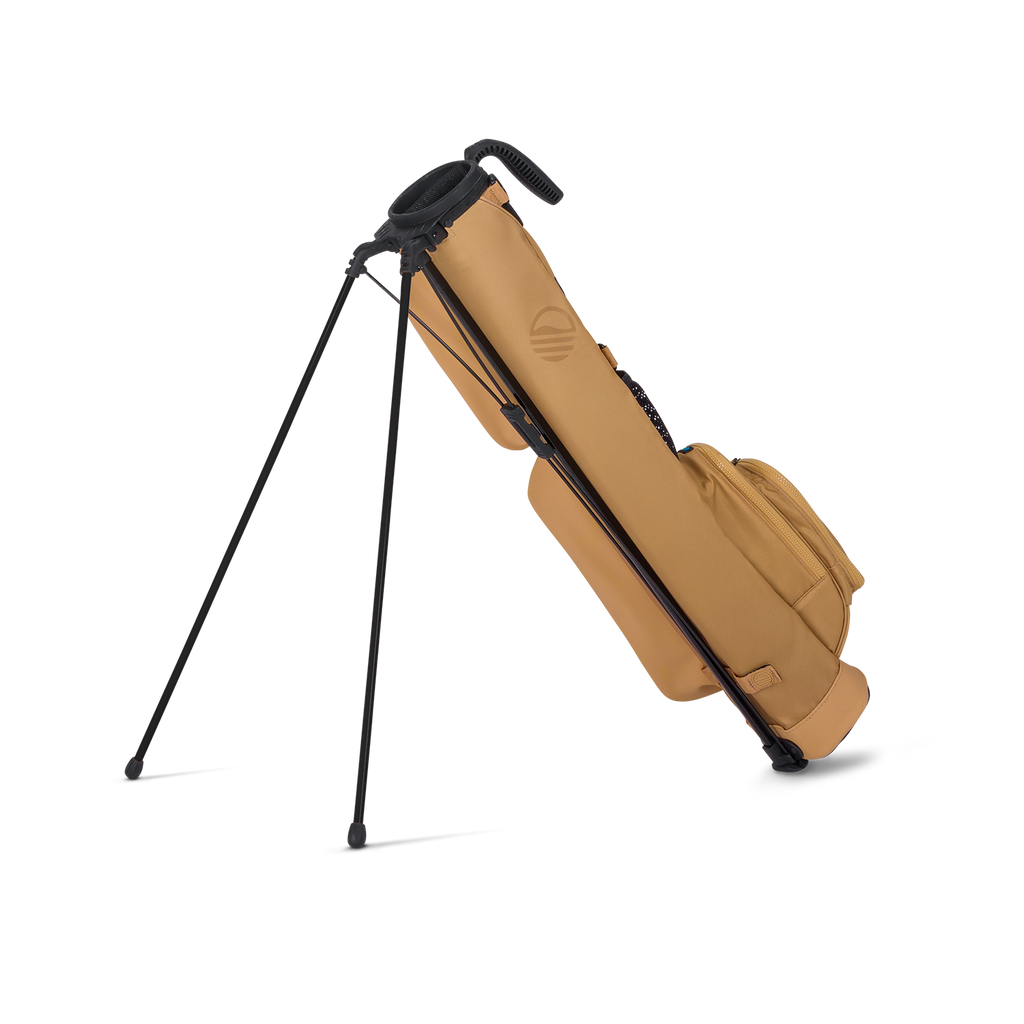 Tan golf bag with black stand on a white background