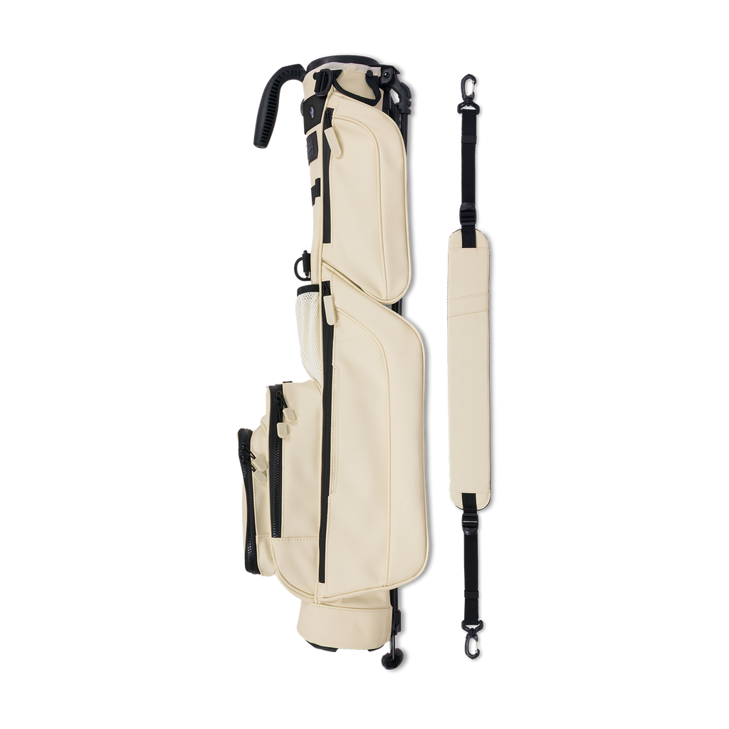A full shot of Loma S-Class golf bag in Cream laying flat sideways beside its single strap
