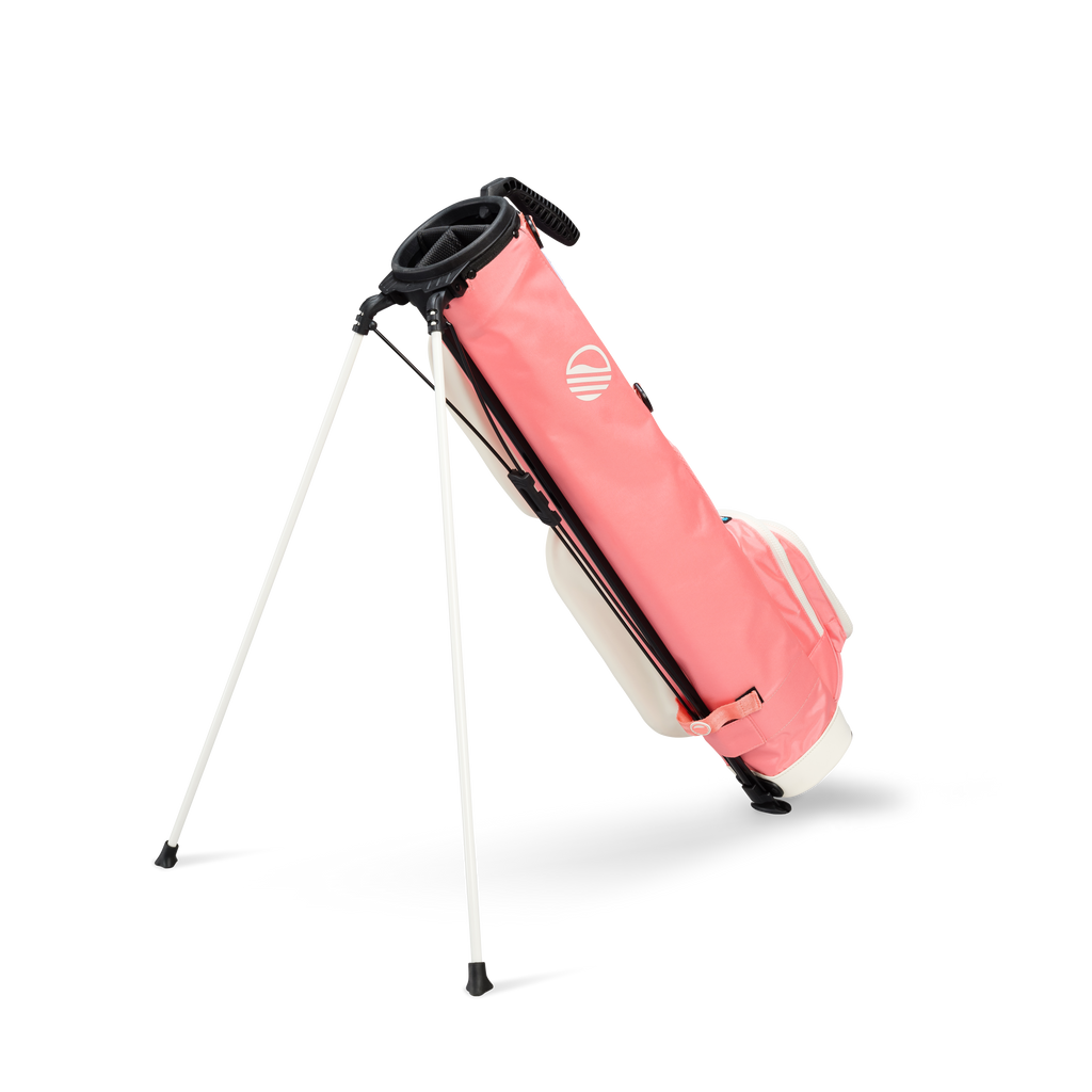 A full shot of standing Loma XL golf bag in coral facing backward