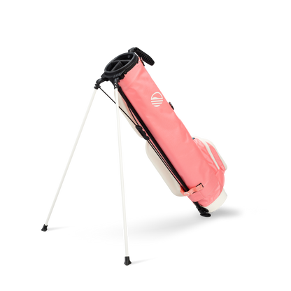 A full shot of standing Loma XL golf bag in coral facing backward