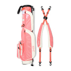 A full shot of Loma XL golf bag in coral laying flat sideways beside its double strap