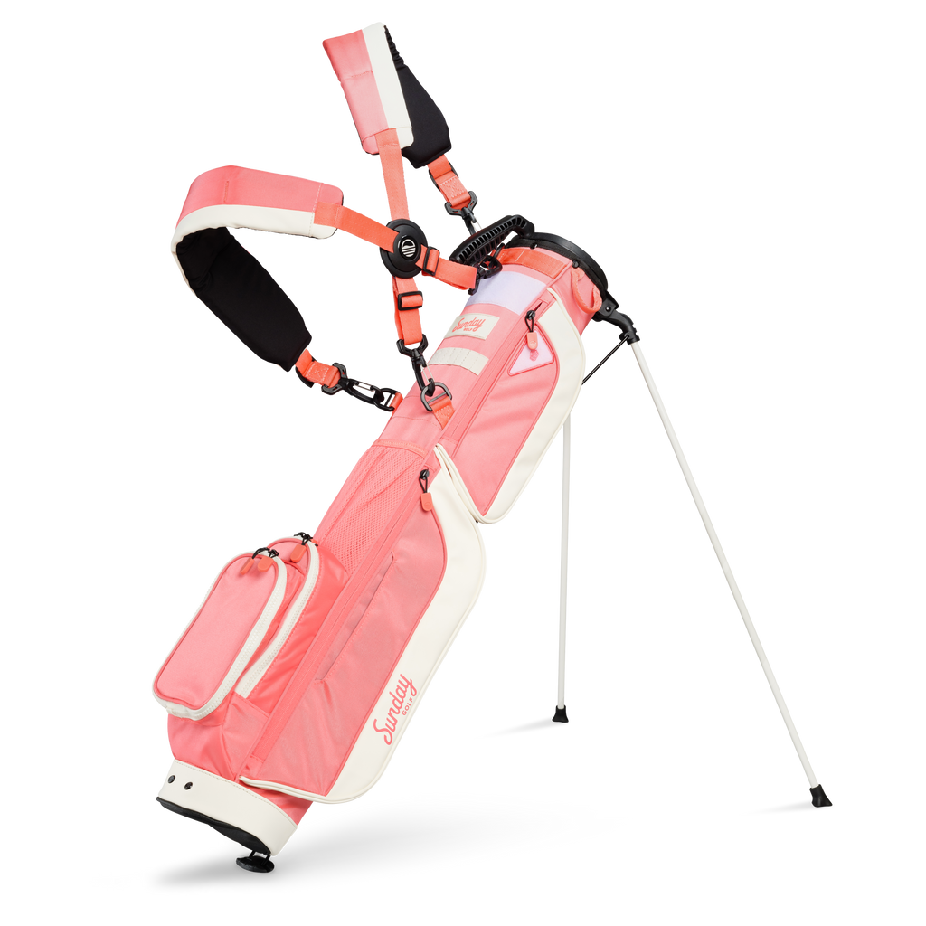 A full front shot of standing Loma XL golf bag in coral with double strap