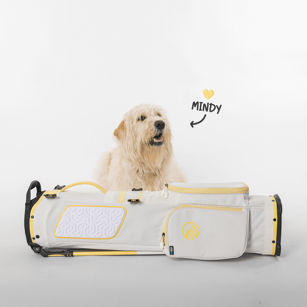 A mid-size stand golf bag named 'Mindy' in lemon and white colors, with a dog sitting on it and a heart symbol above the dog's head.