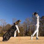 A man playing on the course while his Ryder golf bag in mossy oak bottomland is standing behind him