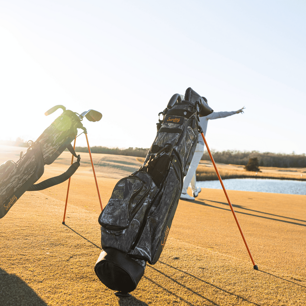 A man playing on the course with a mossy oak country dna Loma golf bag behind him