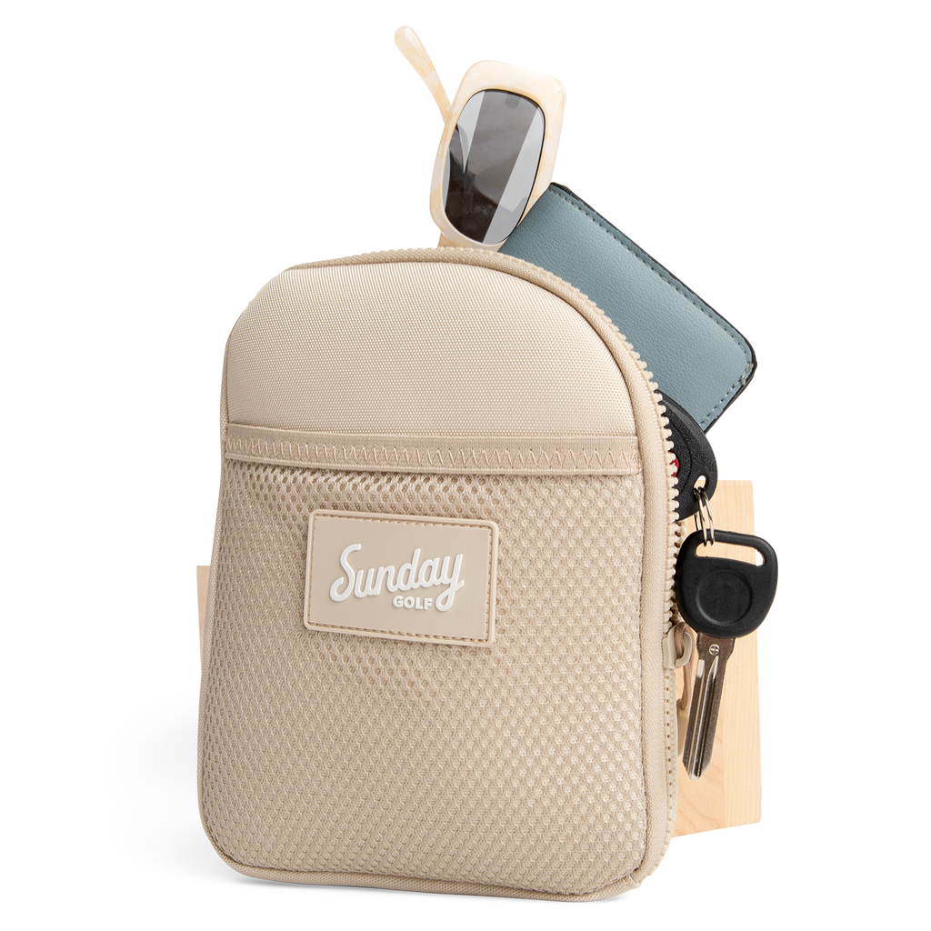 Toasted almond nickel bag valuables pouch unzipped with items showing from inside