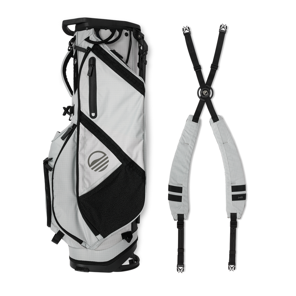 A full shot of Ranger golf bag in Off Gray laying flat sideways beside its double strap
