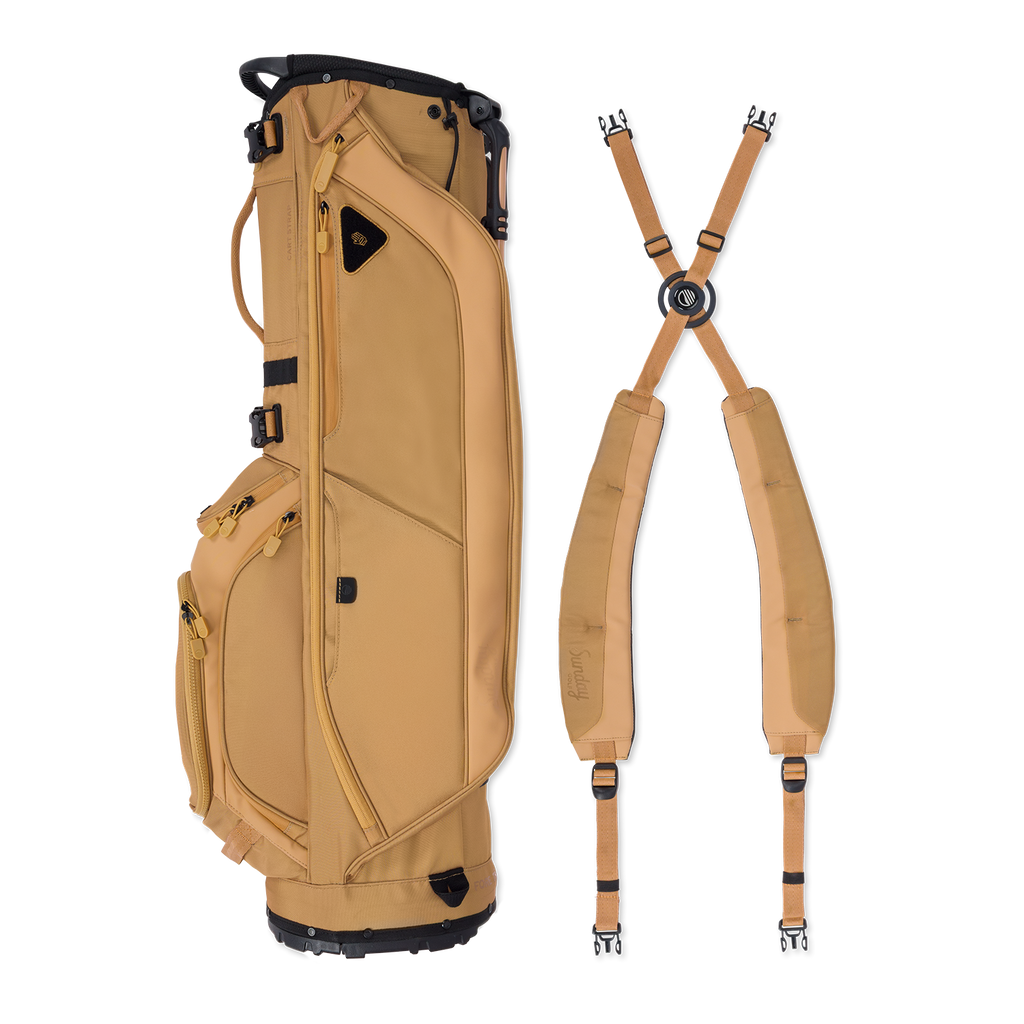 A full shot of Ryder golf bag in clay thompson laying flat sideways beside its double strap
