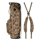 A full shot of Ryder golf bag in Duck Camo laying flat sideways beside its double strap
