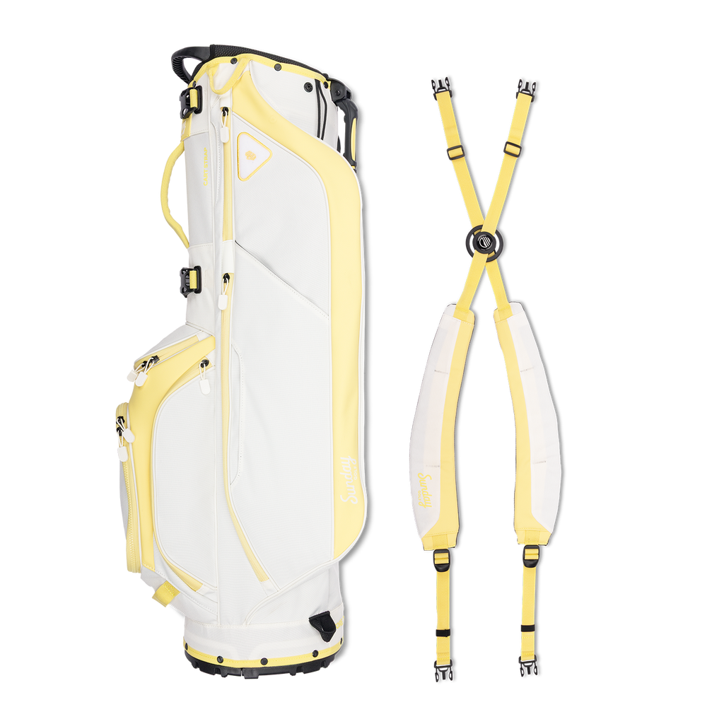 A full shot of Ryder golf bag in mindy lemon laying flat sideways beside its double strap
