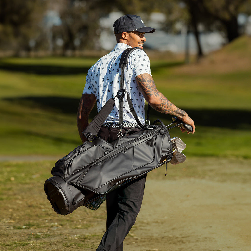 A man on the course carrying a Ryder S-Class golf bag in black vegan leather on his side