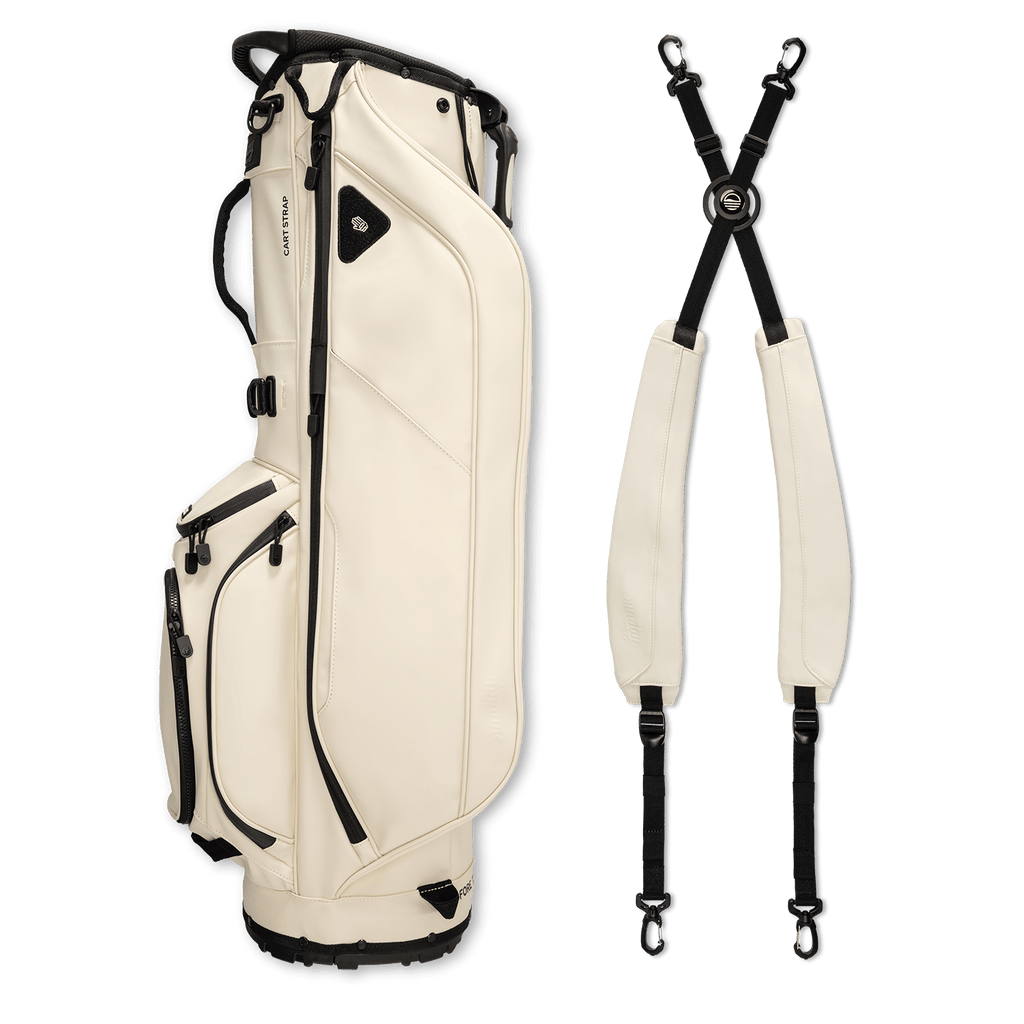 A full shot of Ryder S-Class golf bag in cream vegan leather laying flat sideways beside its double strap