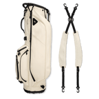 A full shot of Ryder S-Class golf bag in cream vegan leather laying flat sideways beside its double strap