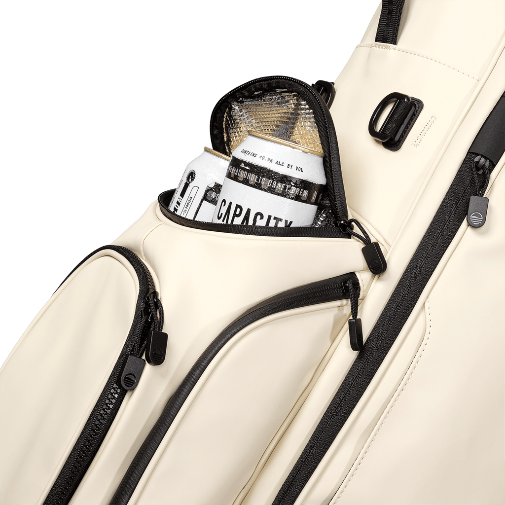 A close up shot of cream vegan leather Ryder S-Class golf bag's frosty pocket with canned drinks inside