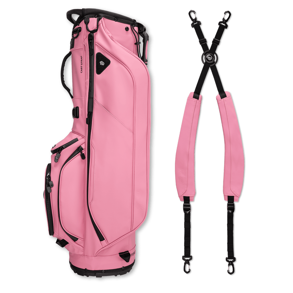 A full shot of Ryder S-Class golf bag in dusty pink vegan leather laying flat sideways beside its double strap