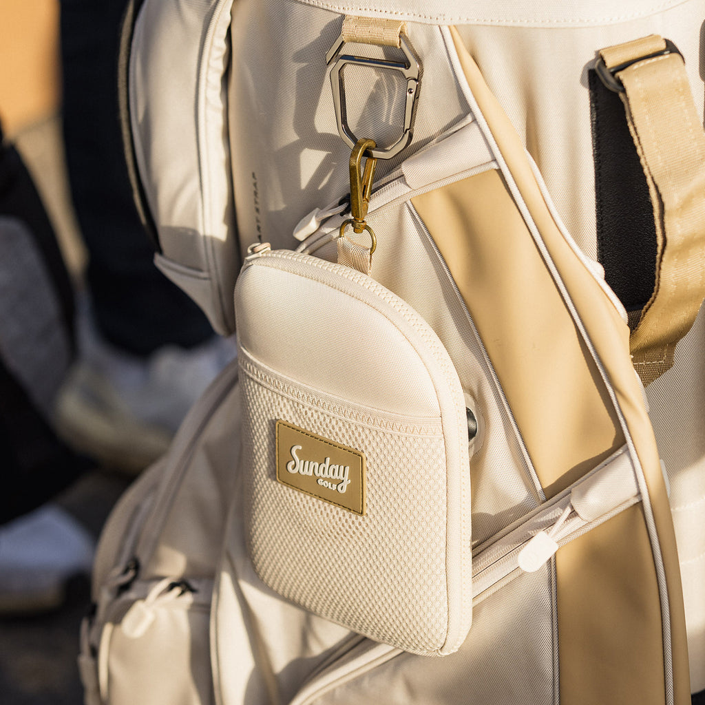 Toasted almond nickel bag valuables pouch clipped on a toasted almond golf bag
