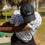 A man wearing black Porter Lite golf hat while playing on the course