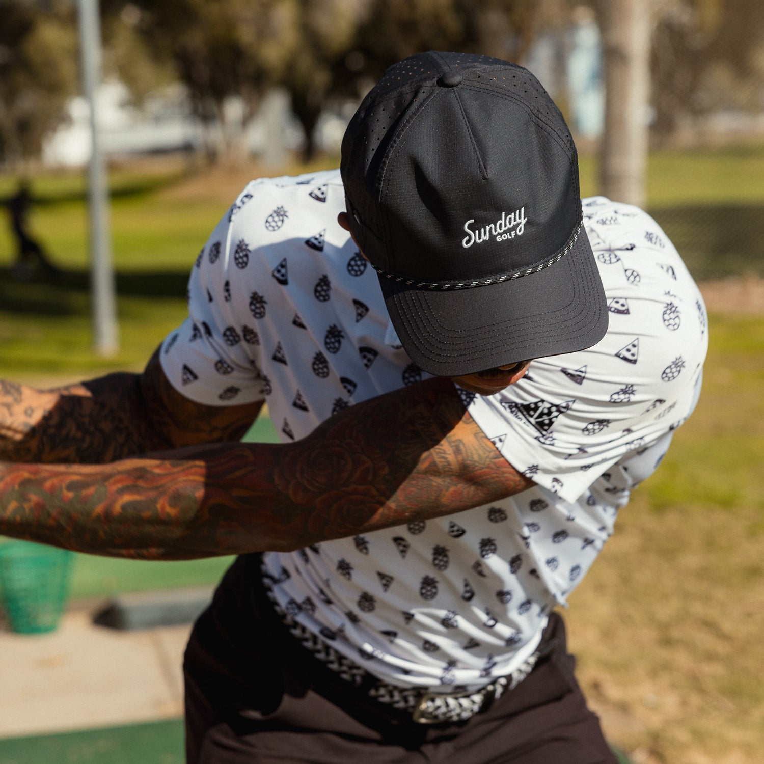 A man wearing black Porter Lite golf hat while playing on the course