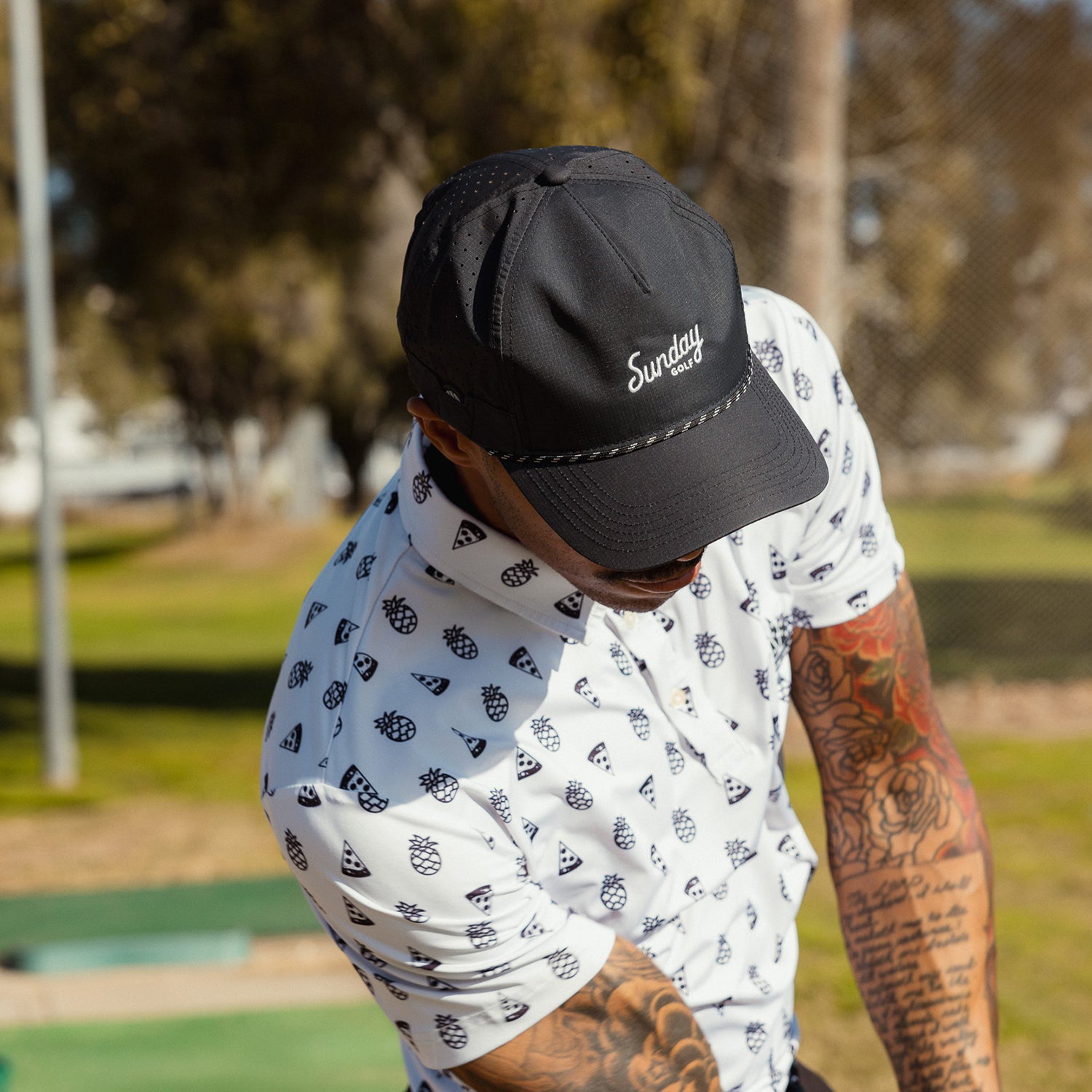 A man wearing black Porter Lite golf hat while playing on the course