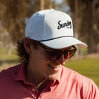 A man wearing white and black rope golf hat and sunglasses
