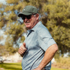 A man smiling while wearing Porter Lite golf hat in olive green