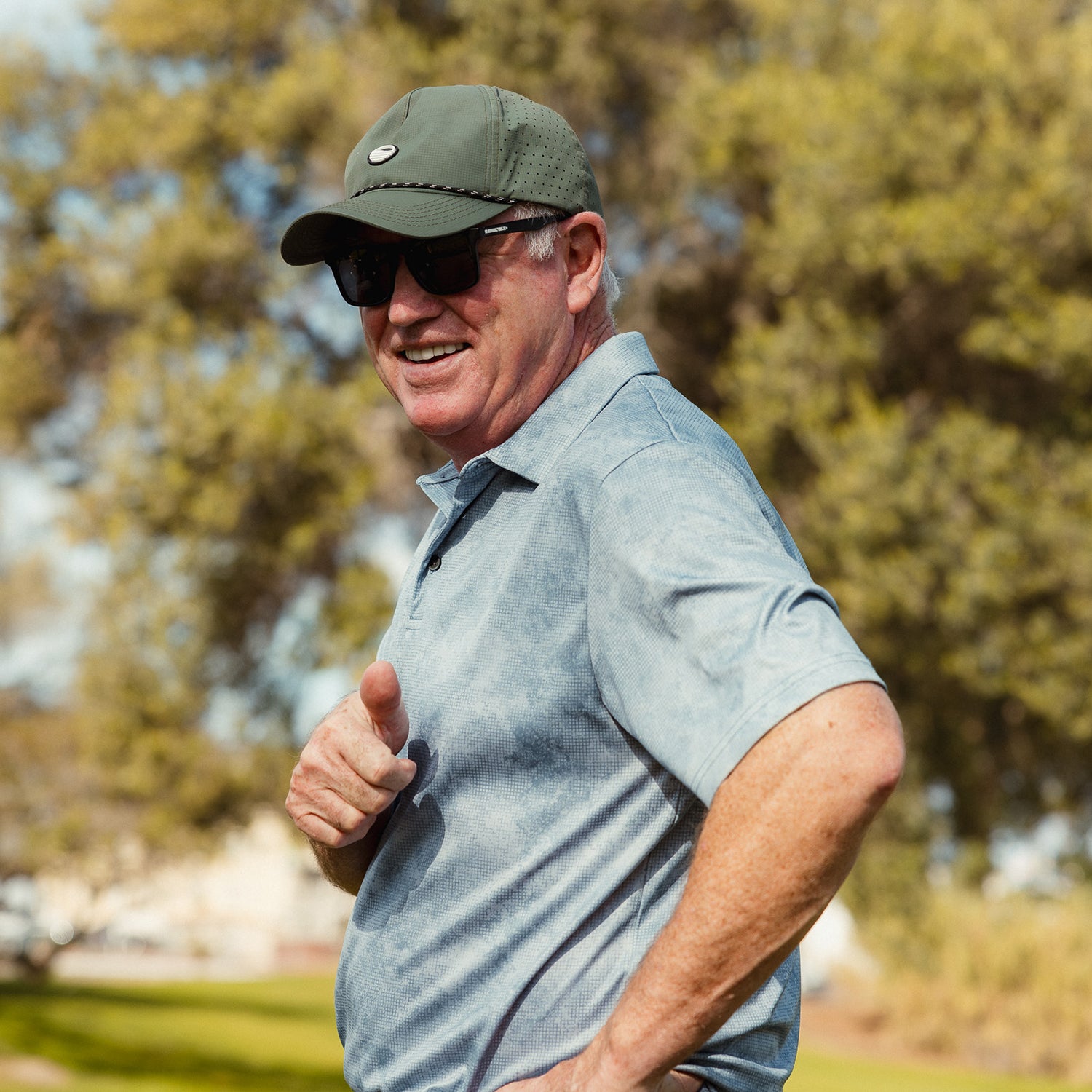 A man smiling while wearing Porter Lite golf hat in olive green