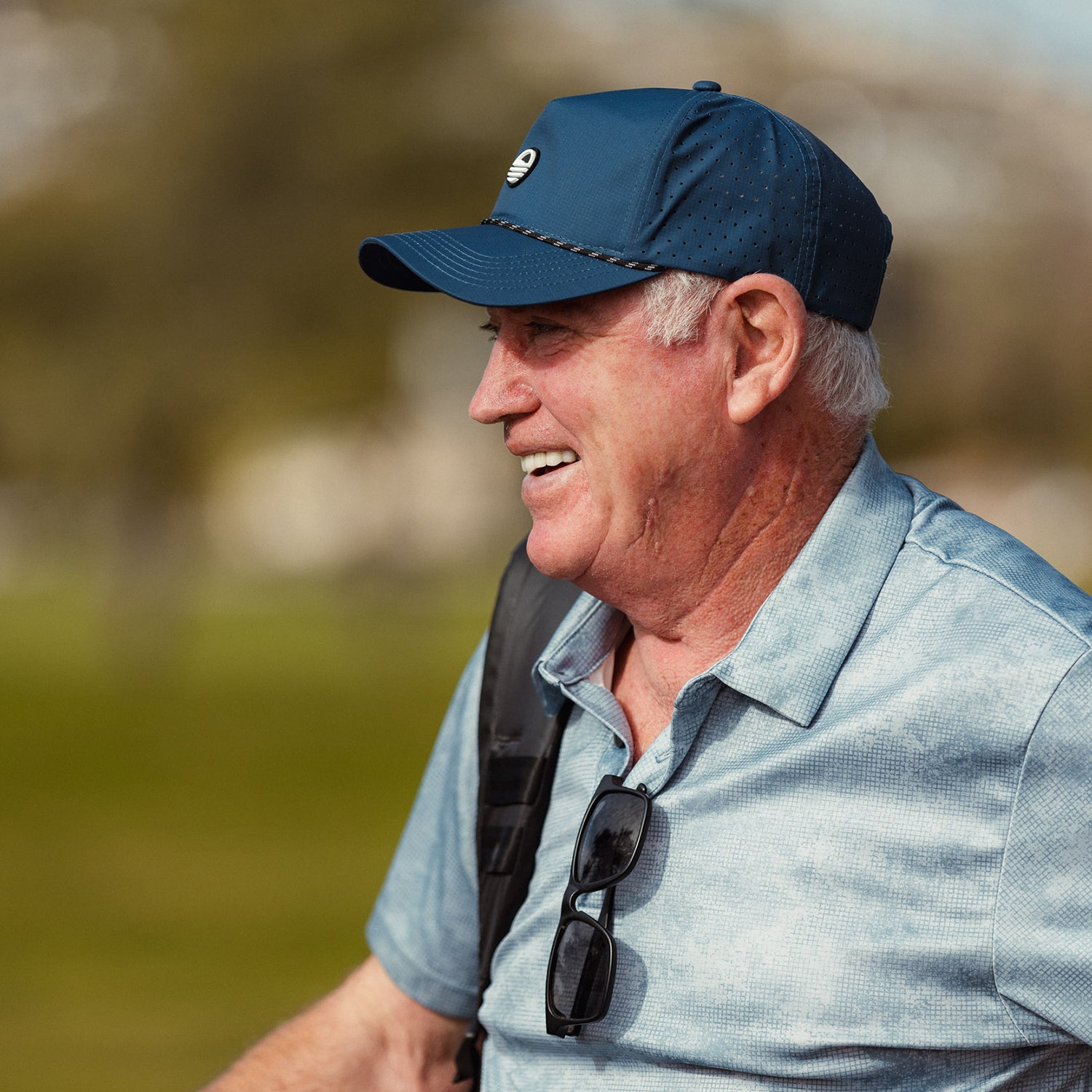A man smiling while wearing navy Porter Lite golf hat