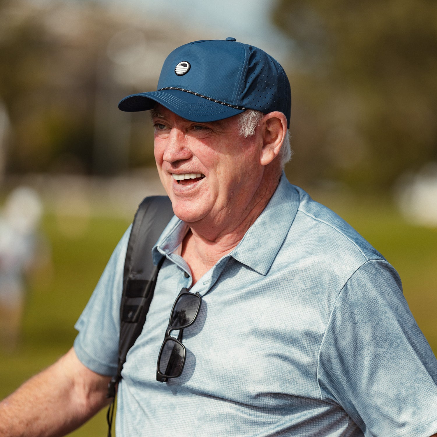 A man smiling while wearing navy Porter Lite golf hat