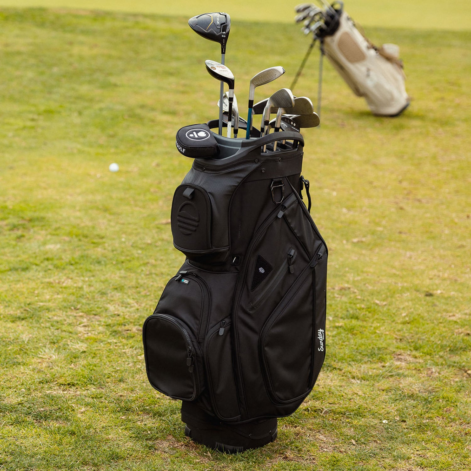 Front shot of Big Rig golf bag in matte black on the course with golf clubs inside