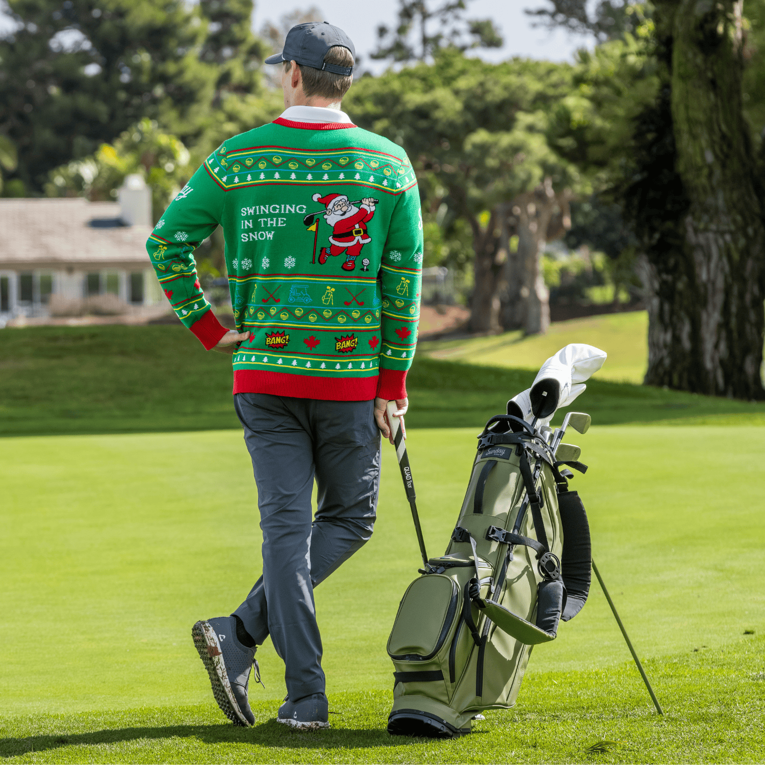 Man wearing the Ugly Sweater walking with a golf bag on a golf course